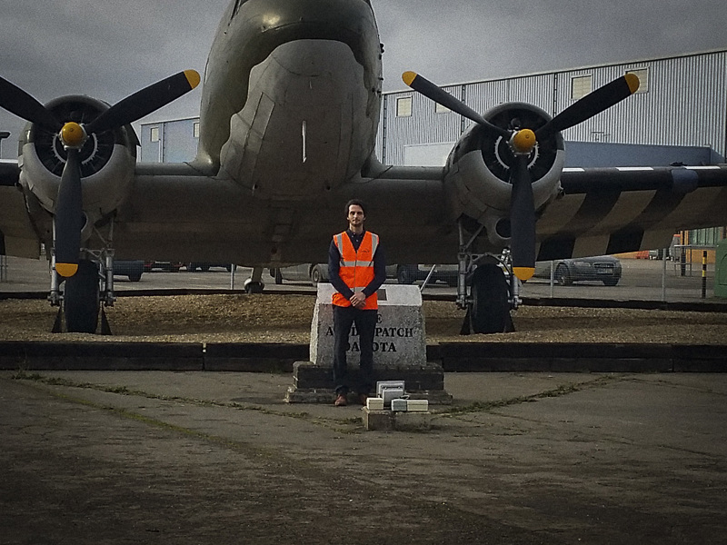 Image of an Amey employee in hi vis, stood in front of an aircraft.