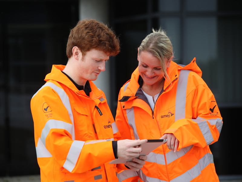 two people in PPE, inspecting a map.