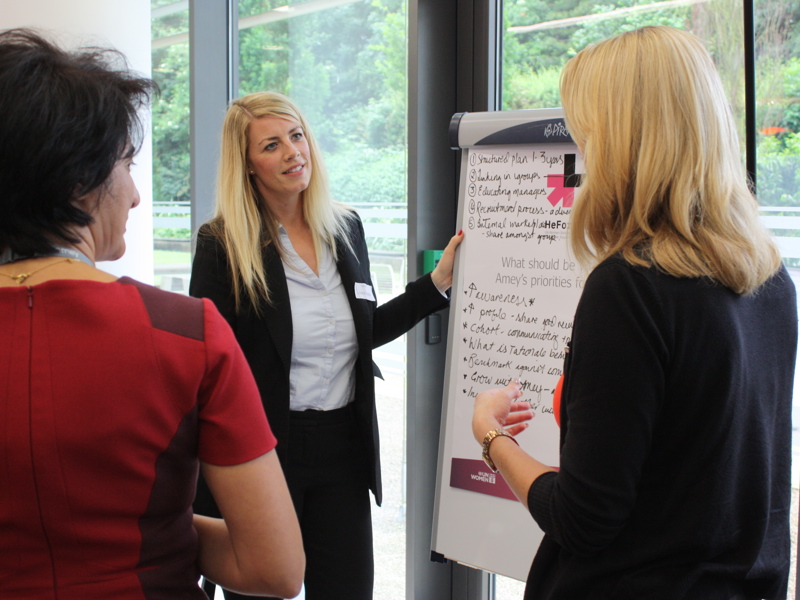 Image of three female Amey employees collaborating at work.