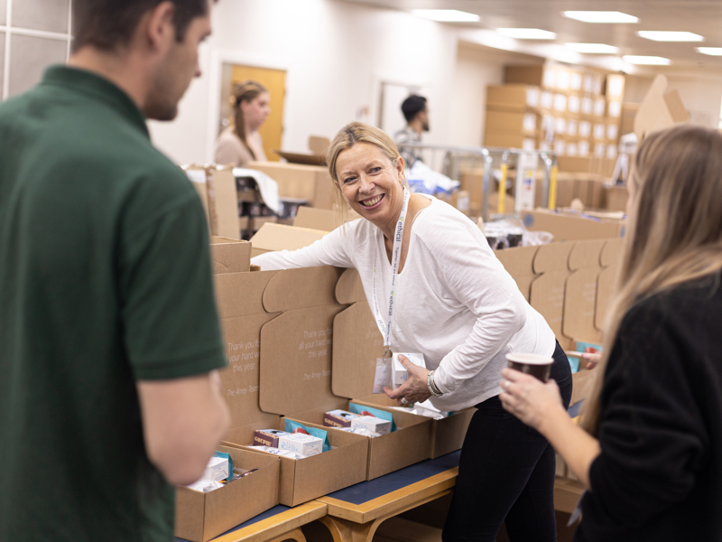 A image of a woman retrieving an object from a box.