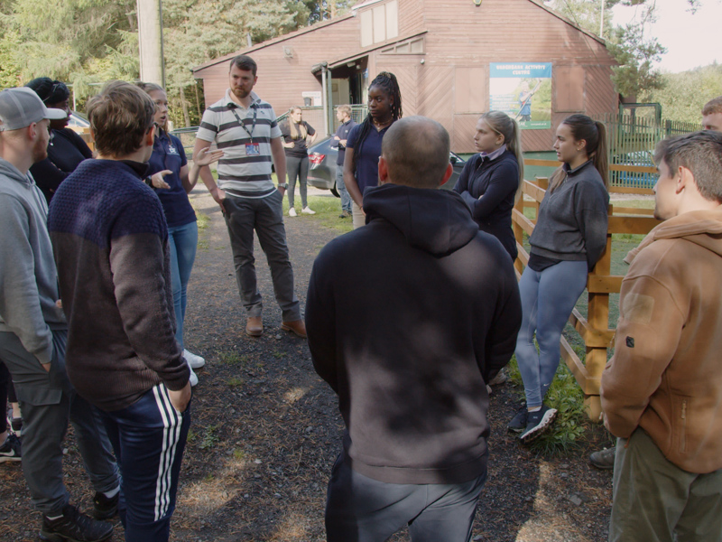 An image of a group of people stood around in a circle.