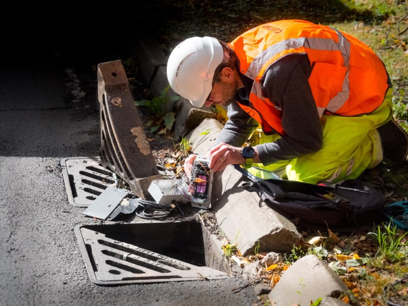 Image of a man in PPE carrying out work on a drain.