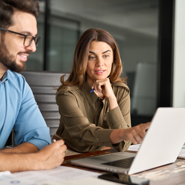 Image of two work colleagues looking at laptop