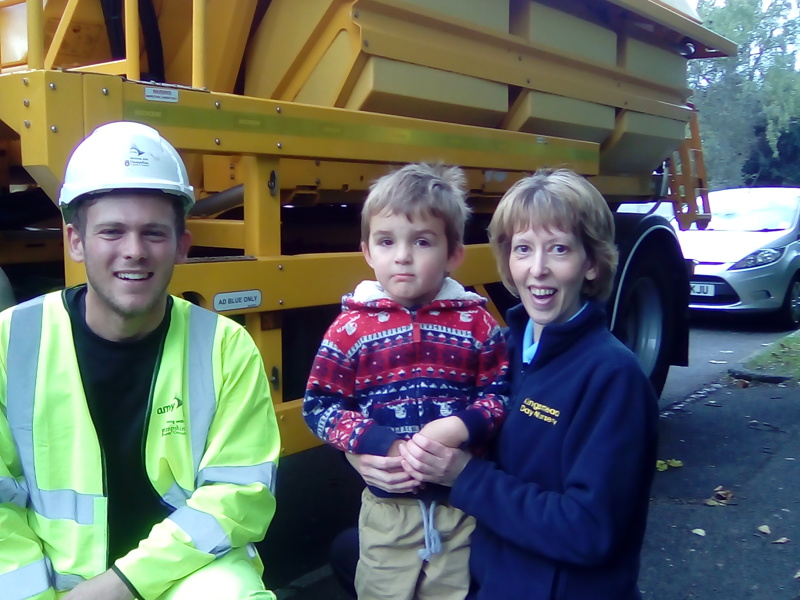 Image of nursery employee and child, with Amey employee in front of a gritter names 'Prince'.