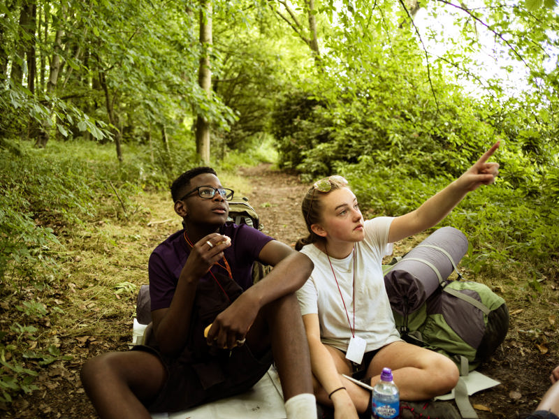 two young people sat in the woods.