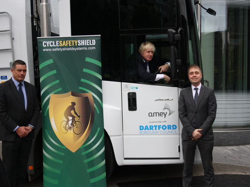 A man in a van, with two stood outside next to a Cycle safety banner.