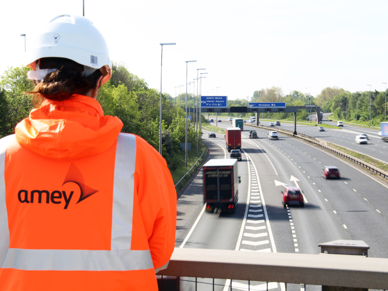 woman on a bridge, overlooking the high way.
