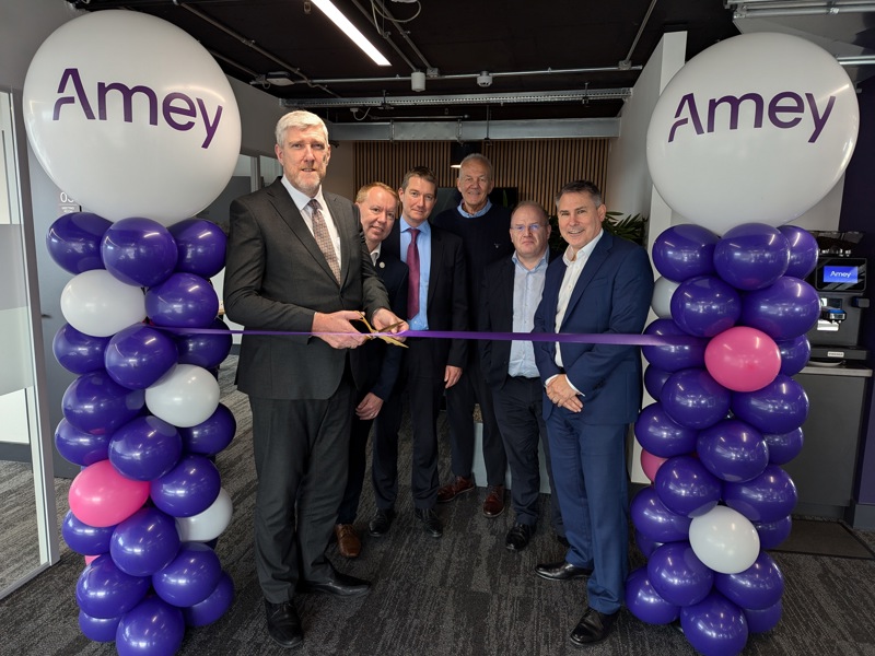 Amey employees cutting a ribbon to celebrate the Belfast office opening