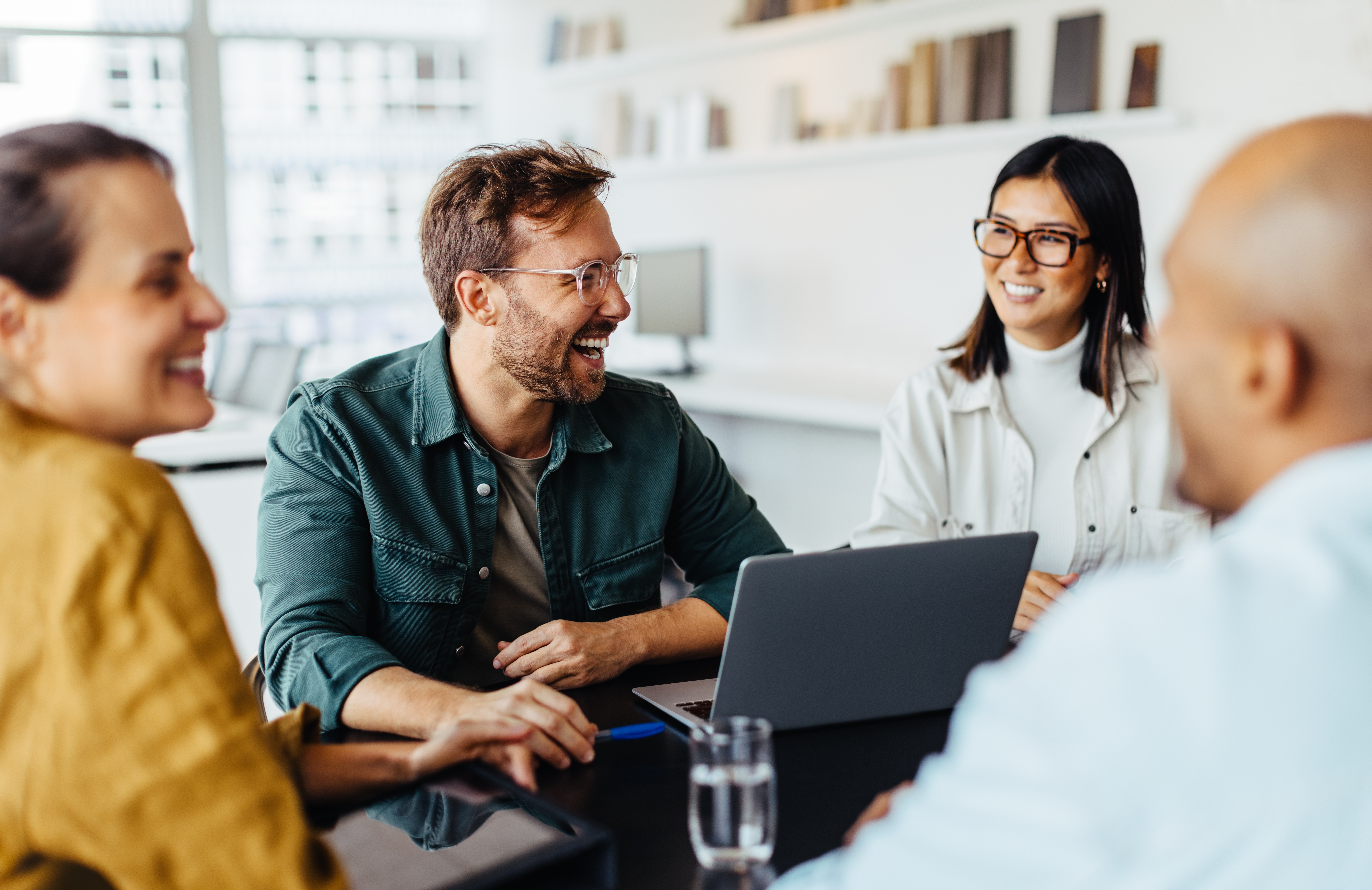 Employees gathered around a desk during a team discussion.