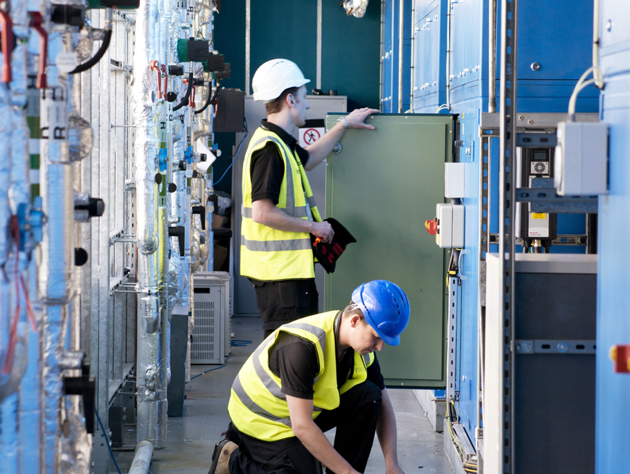 Two Amey employees working within a control room.