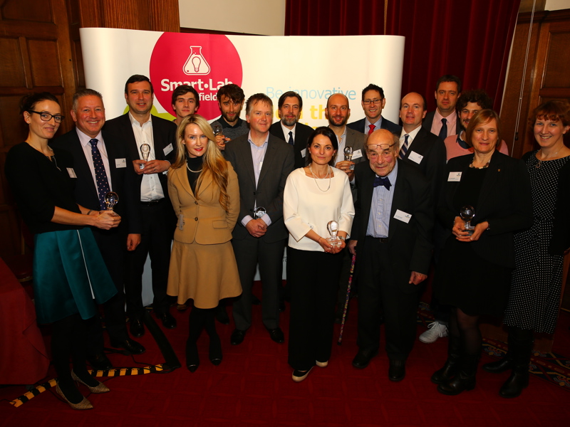 A group of Amey employees, in formal attire, holding an award.