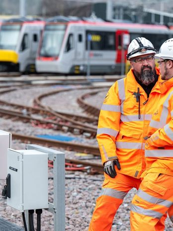 Twp men in Person Protective Equipment in a train depot
