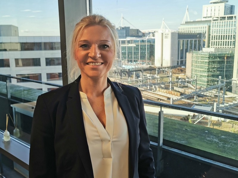 Image of Caroline Lewis, stood in front of a window.