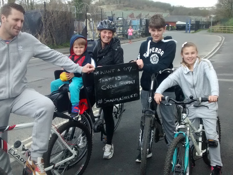 A picture of a family riding bikes in the city.