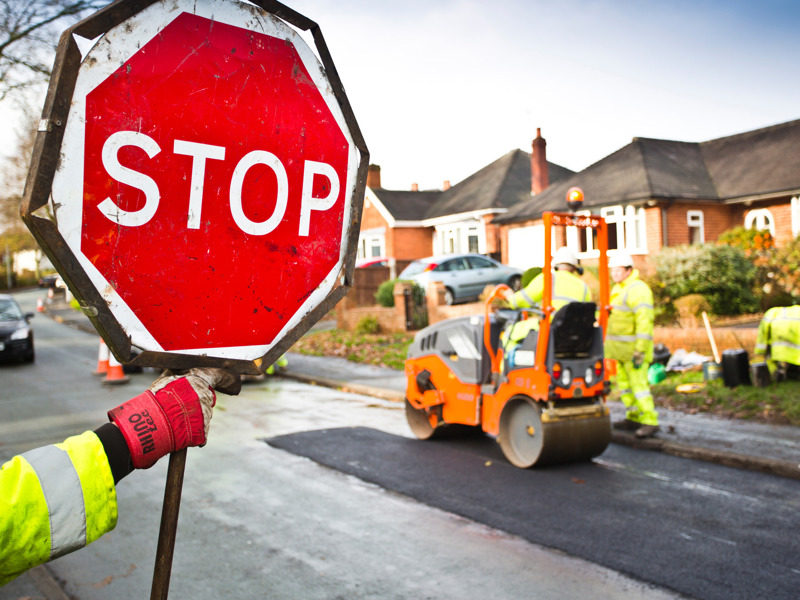 Image of a man holding a stop sign.