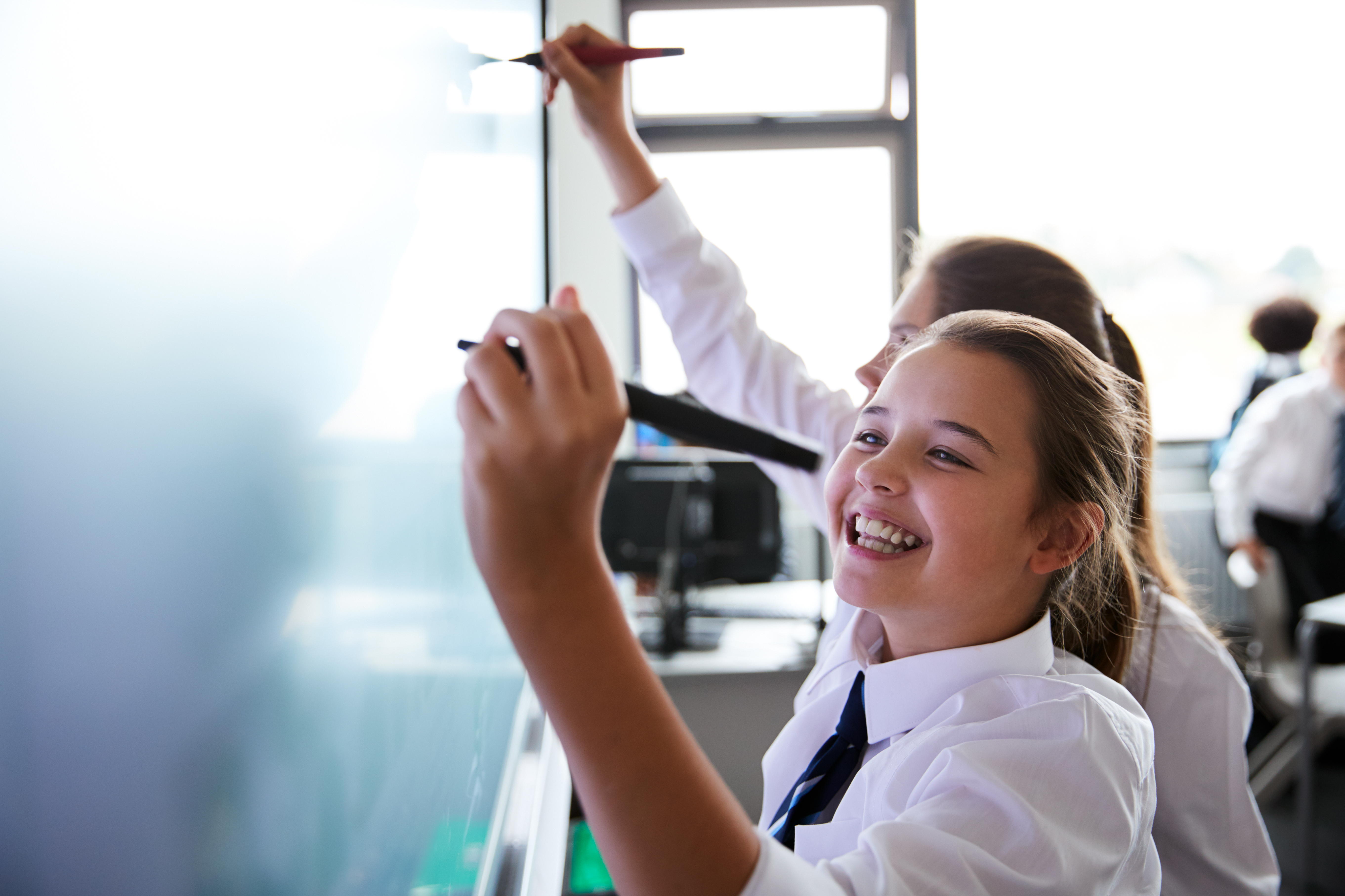 Image of school pupil writing on whiteboard