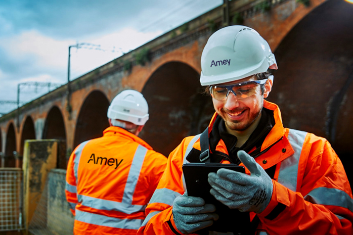 Two men in PPE stood in front of a bridge