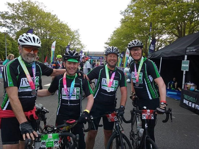 Image of four men in cycling gear on bikes.