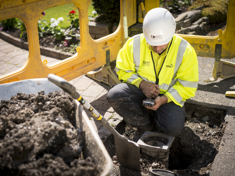 A man in PPE taking a meter reading.