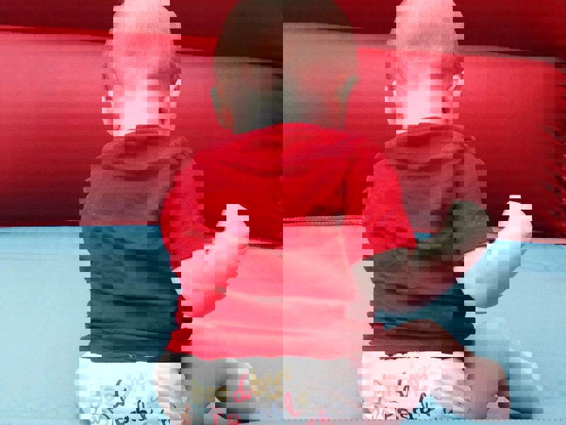 Image of a baby sat on a bouncy castle.