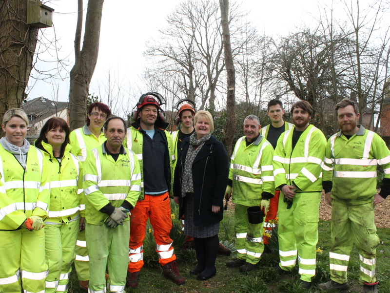 Group of people wearing PPE, stood in front of a school.
