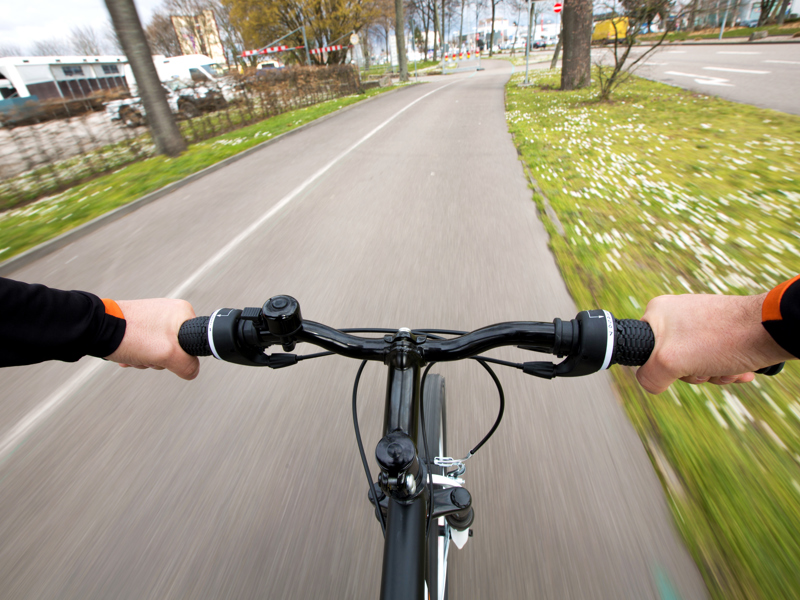 Image of a male holding a bike's handle bars.