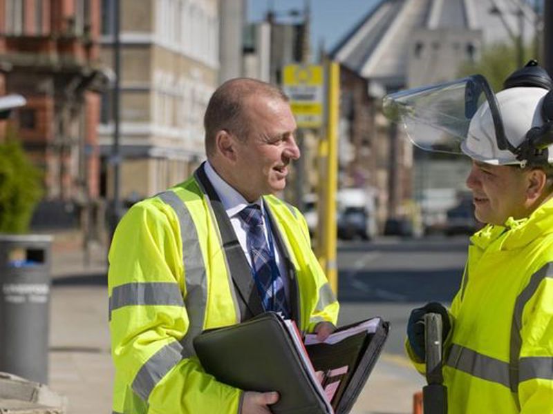 Two men in PPE, chatting.