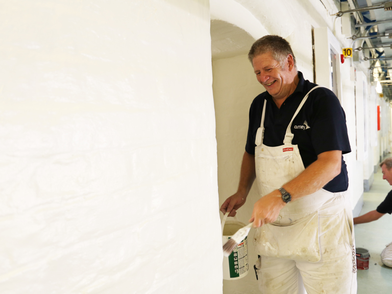 two men painting a hallway.