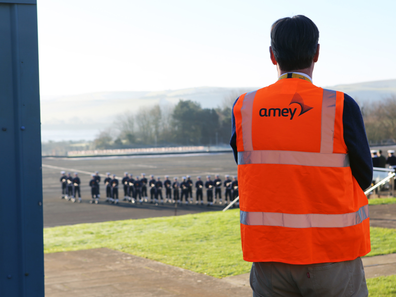 A man in a hi vis jacket looking out a window.