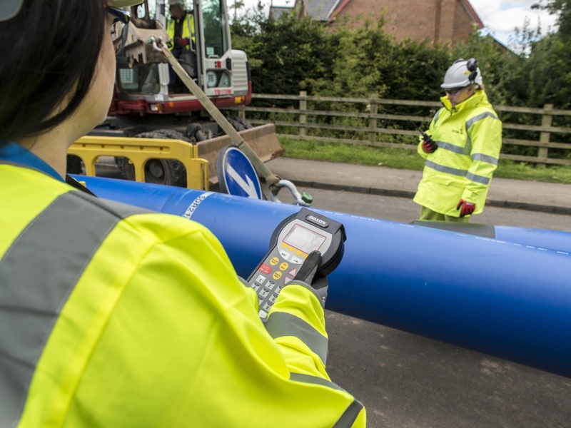Image of two women in PPE, holding a meter reader.