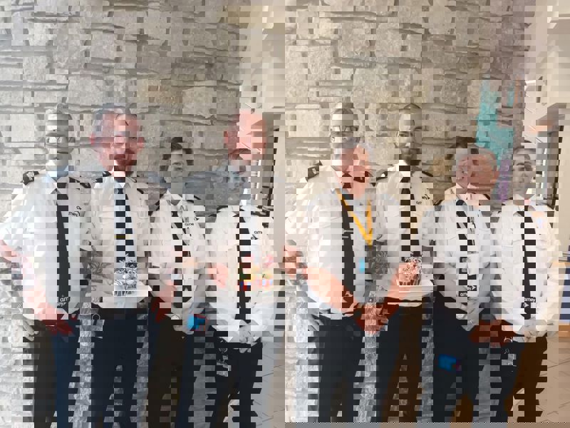 Amey security employees holding cupcakes. 