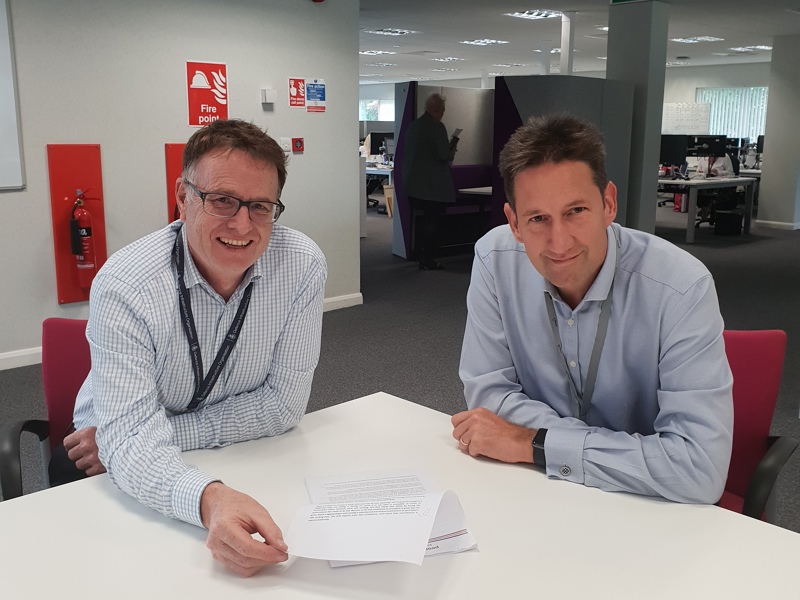 Image of two Amey employees at a desk in an office.