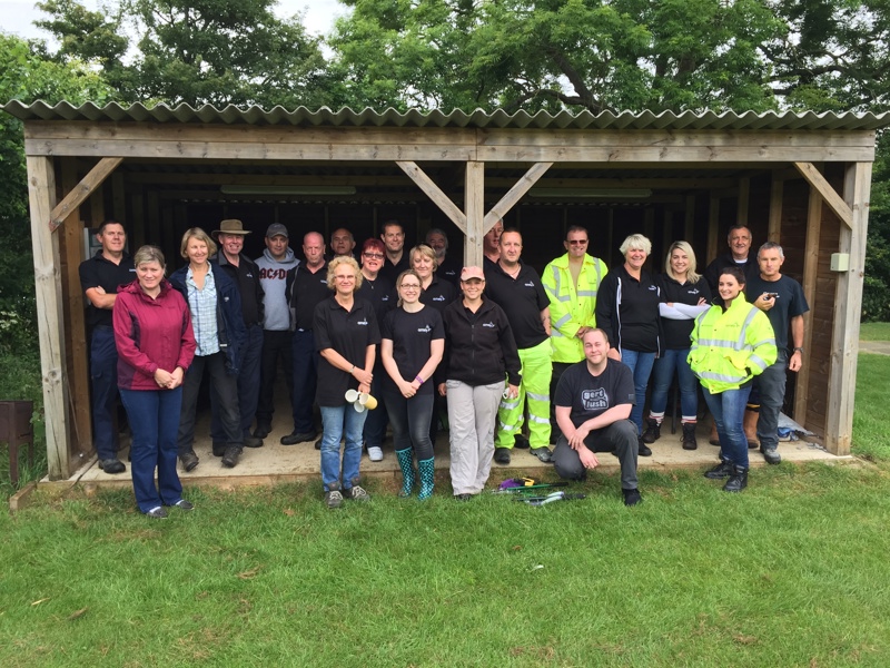 Team photo of Amey employees stood under a shelter.