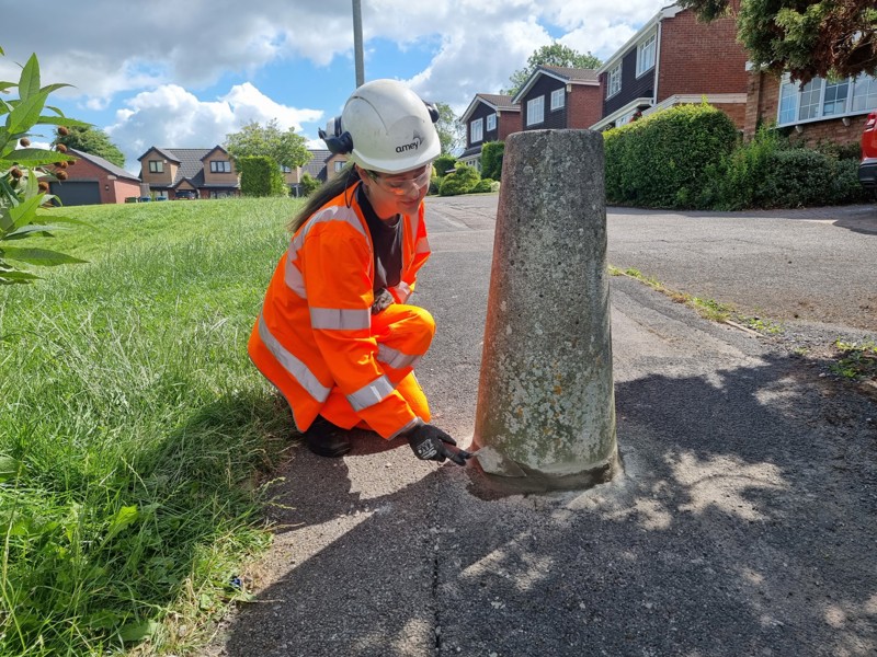 Amey female employee, wearing PPE, repairing a concert post.