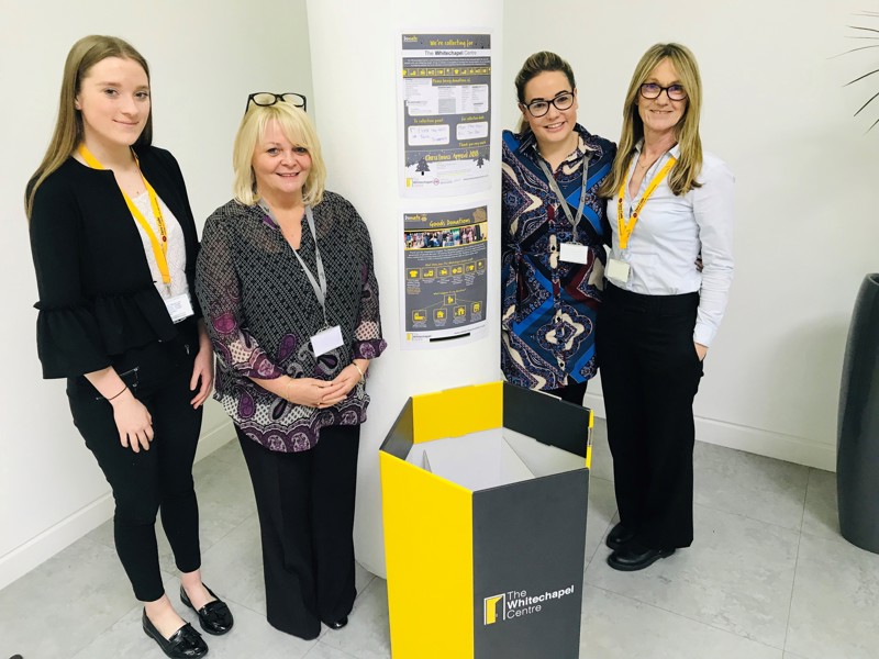 Image of Amey employees stood by a pillar in an office.