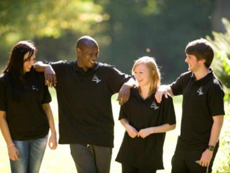 Four young Amey employees, standing chatting.