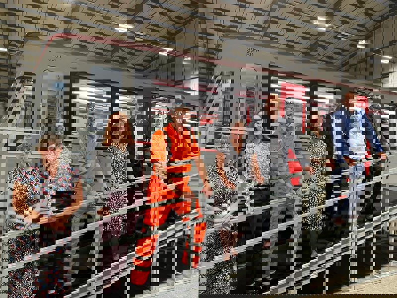 Image of Amey employees stood on a ramp at a rail platform.