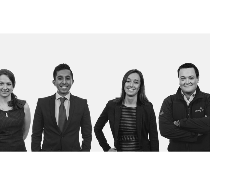 A black and white, group image of four people, stood in a line.