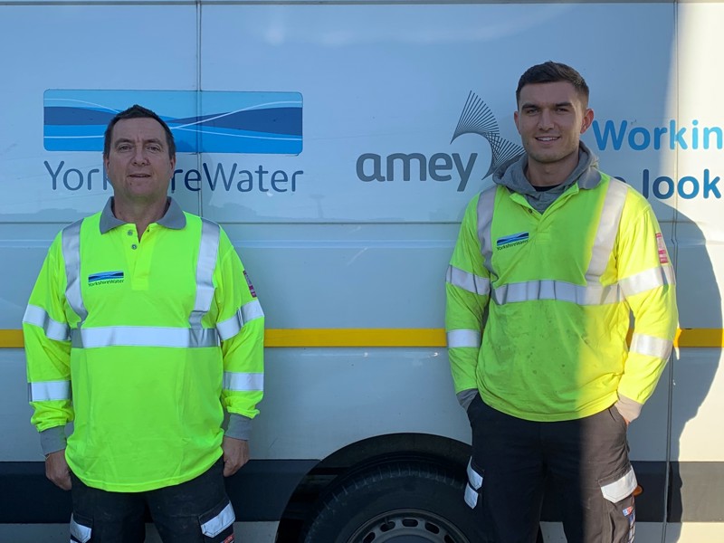 Image of Amey utilities workers stood in front of a van.