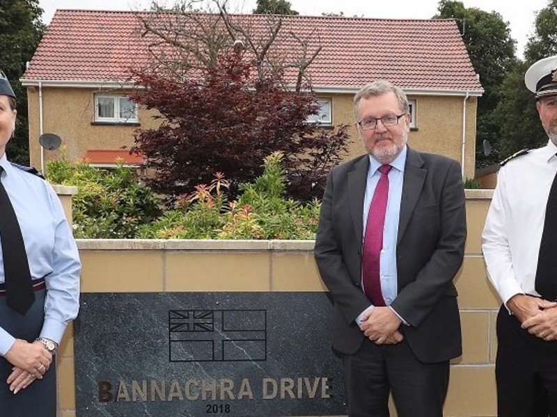 Three people stood by a sign as part of a refurbishment project.