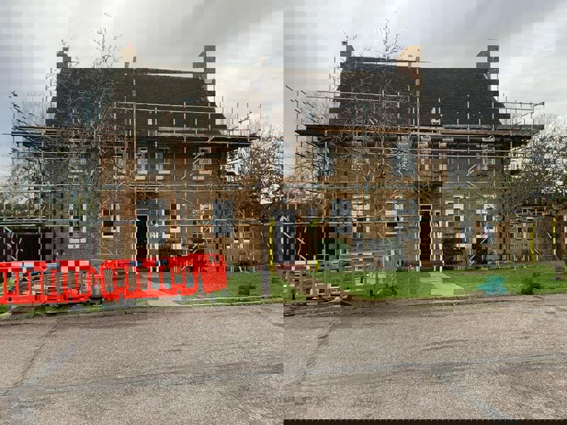 Image of a house surrounded by scaffolding.