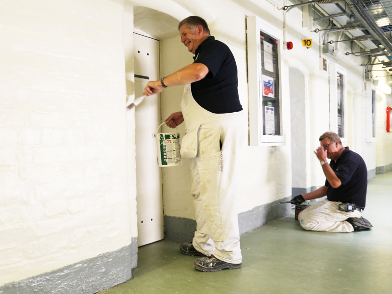 men painting a hallway.