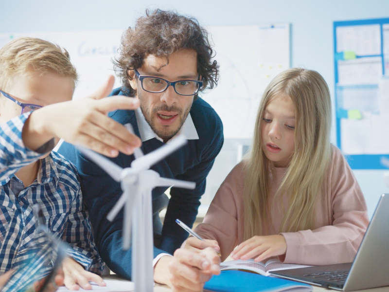 Children and a mentor learning STEM.