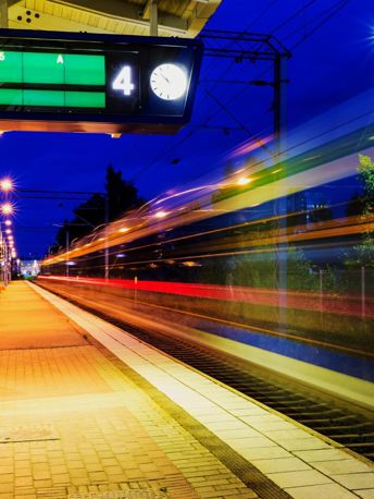 Image of a rail platform with a passing train.