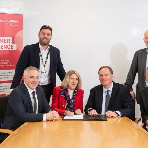 A group of Amey employees, signing a document.
