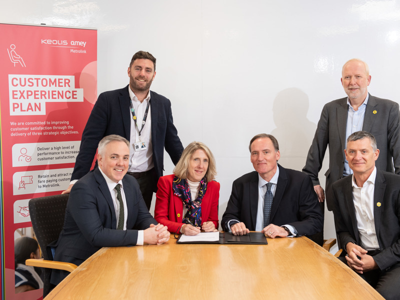 A group of Amey employees, signing a document.