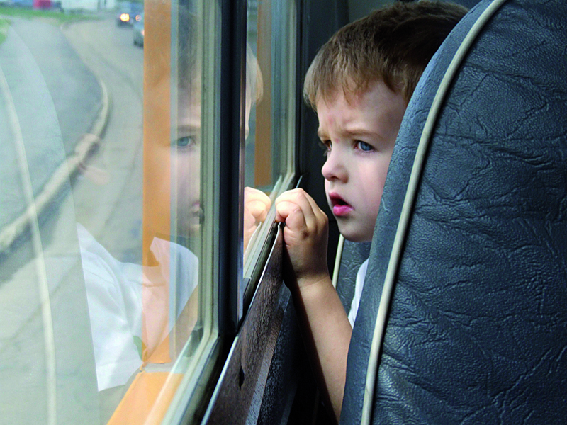 Image of a child looking out of a bus window.