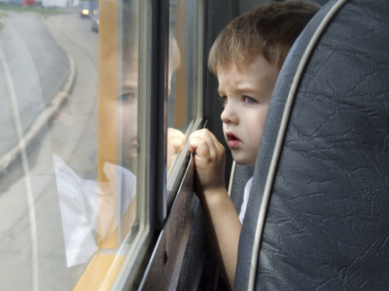 a child looking out of a bus window.