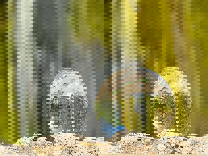 a glass sphere, in front of a waterfall.
